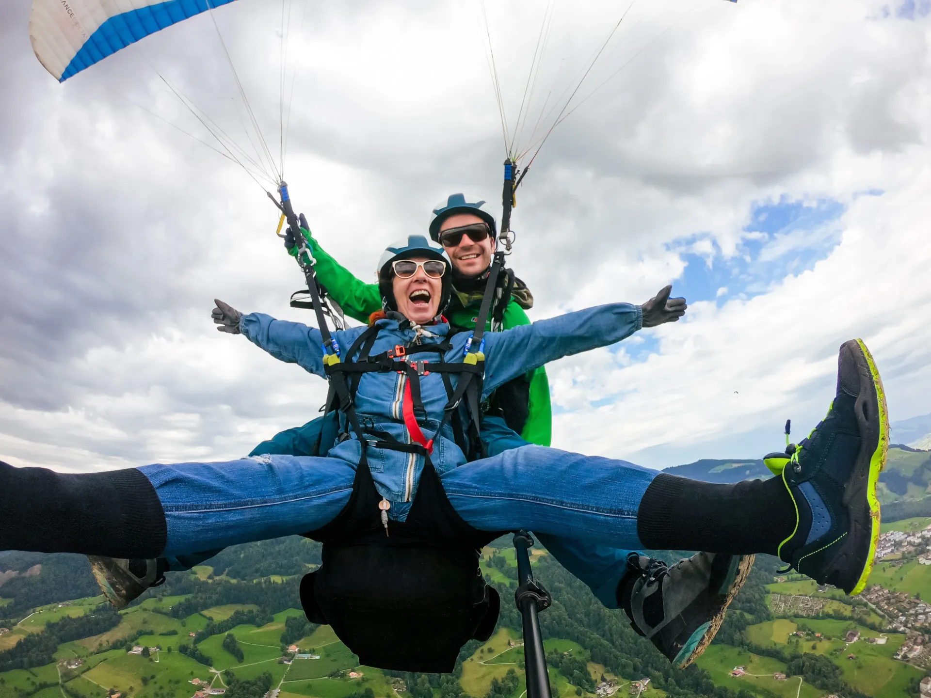 Happy paragliding passenger with Lake Lucerne and Swiss Alps in the background